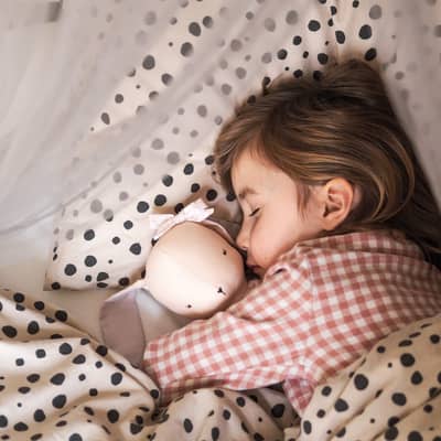 child asleep with cloth doll