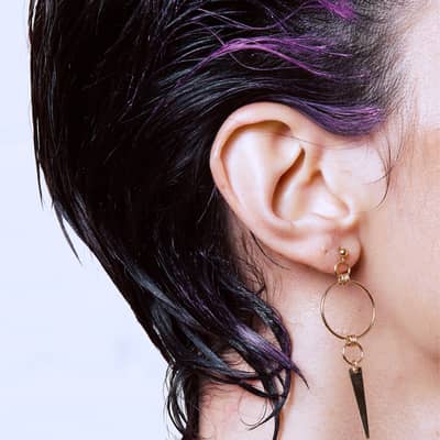 Model image with earrings with spikes and studs, gold