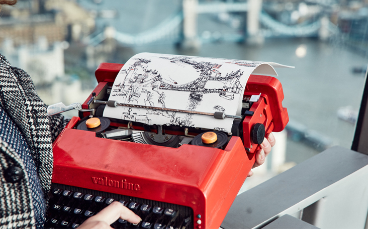 Keira Rathbone typewriter artist typing from life Tower Bridge from the Sky Garden Tower bridge on page and in background finger on key red Olivetti Valentine