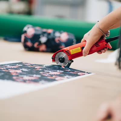 Someone cutting out the material for a head cover.
