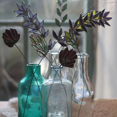 Selection of wildflowers and grasses displayed in glass bottles