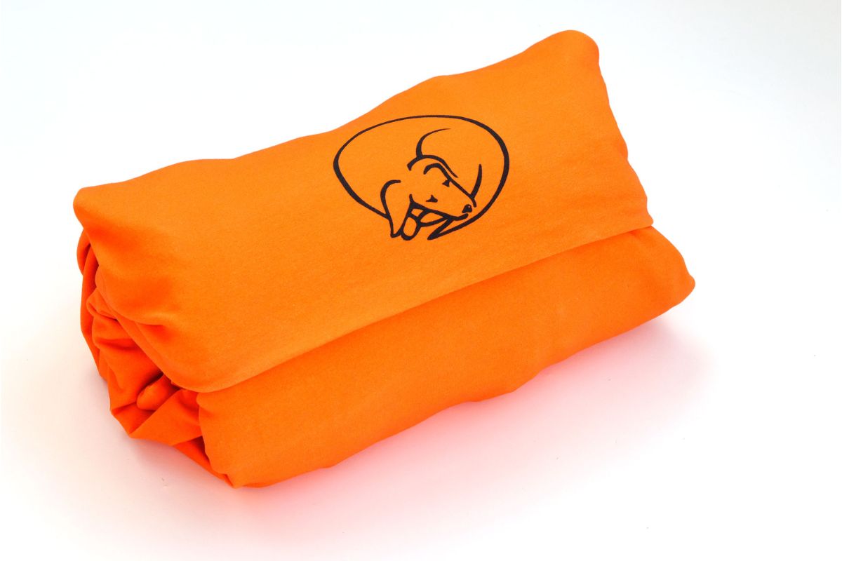 An orange Fold+Roll fabric roll filled with clothes