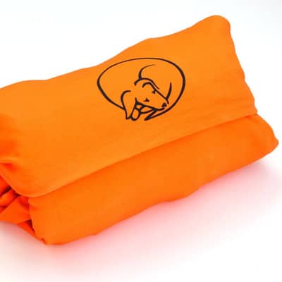 An orange Fold+Roll fabric roll filled with clothes