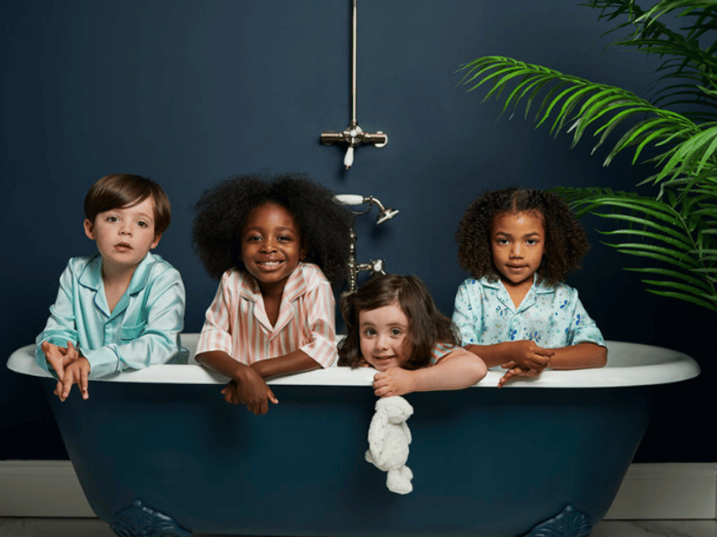 Four children wearing Sleepy Wilson pyjamas sitting in a bath