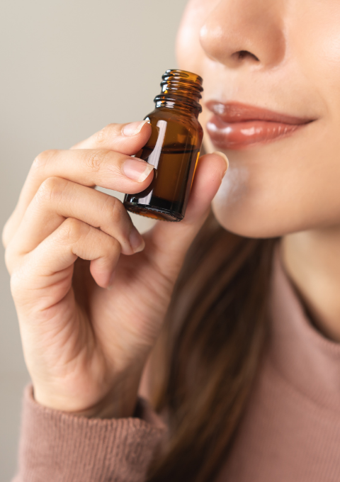 A woman smelling an essential oil to feel relaxed