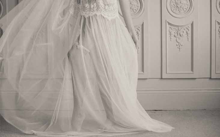 Bride reclines on bed in garter