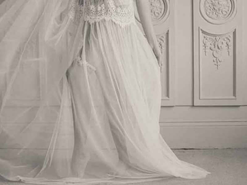 Bride reclines on bed in garter