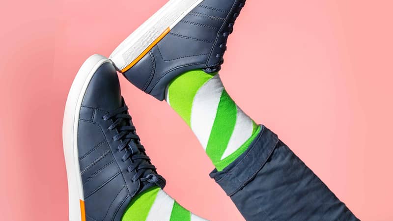 Luxury green and white striped socks for men in blue trainers
