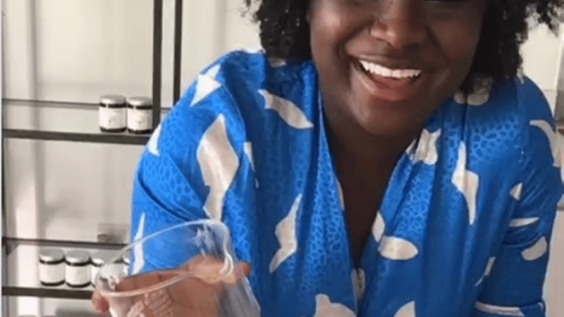 Ricki in a blue dress making candles