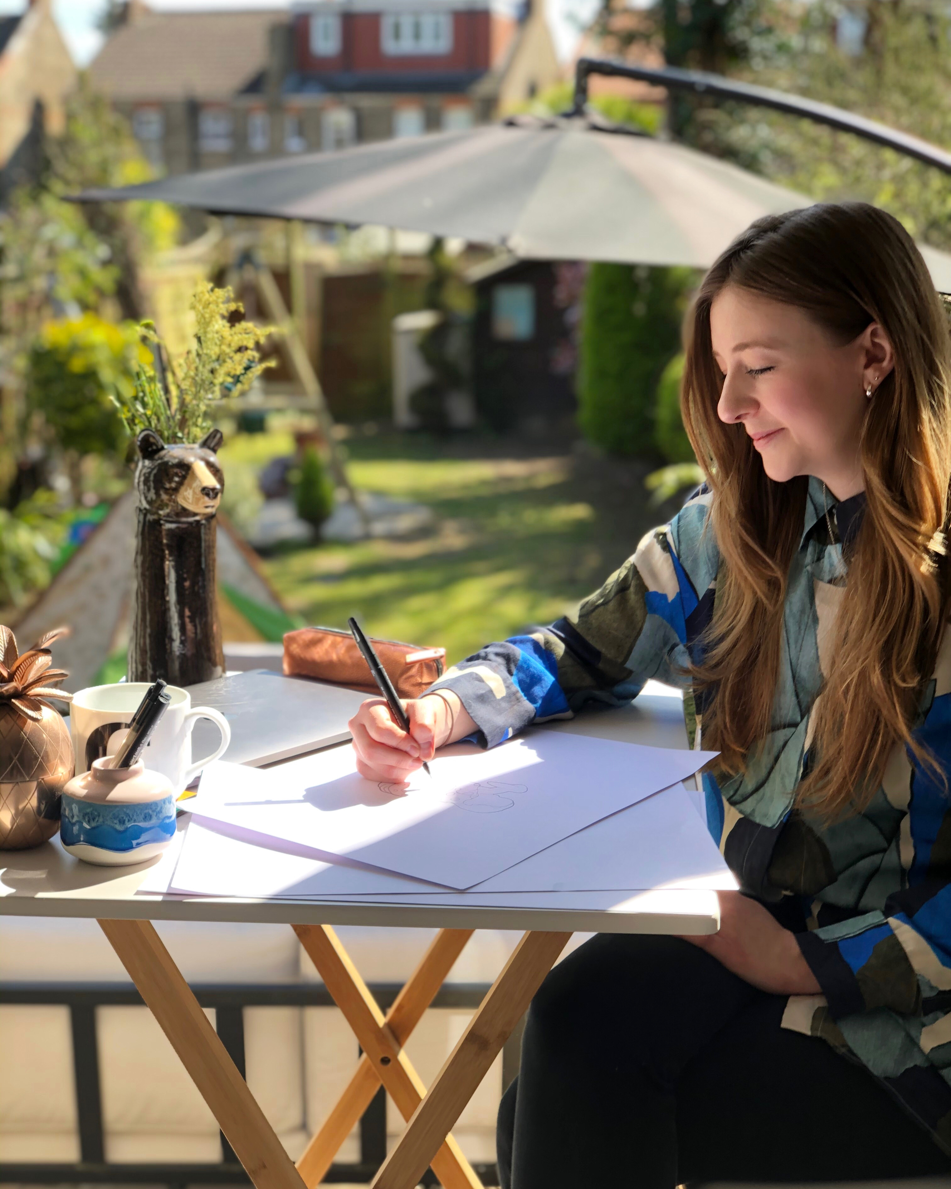 Charlotte Evans, the illustrator and owner of La Fam Illustration at her desk.