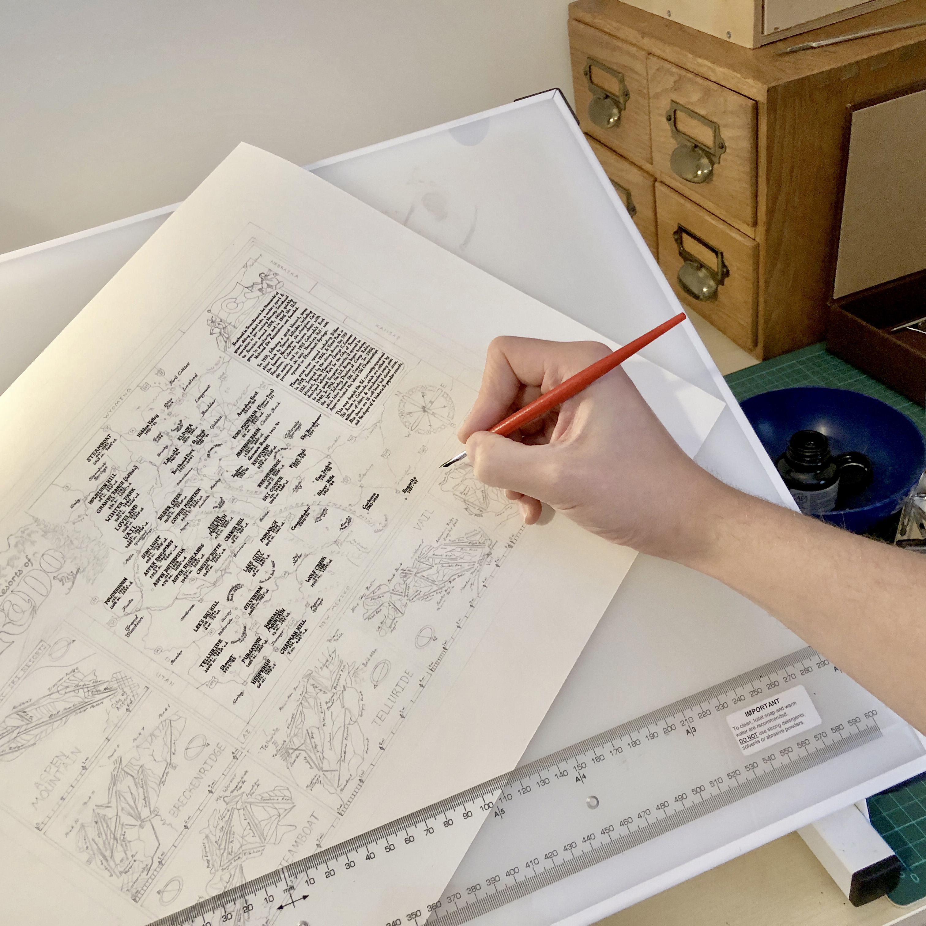 Photo hand writing place names onto a map