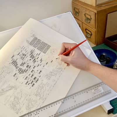 Photo hand writing place names onto a map