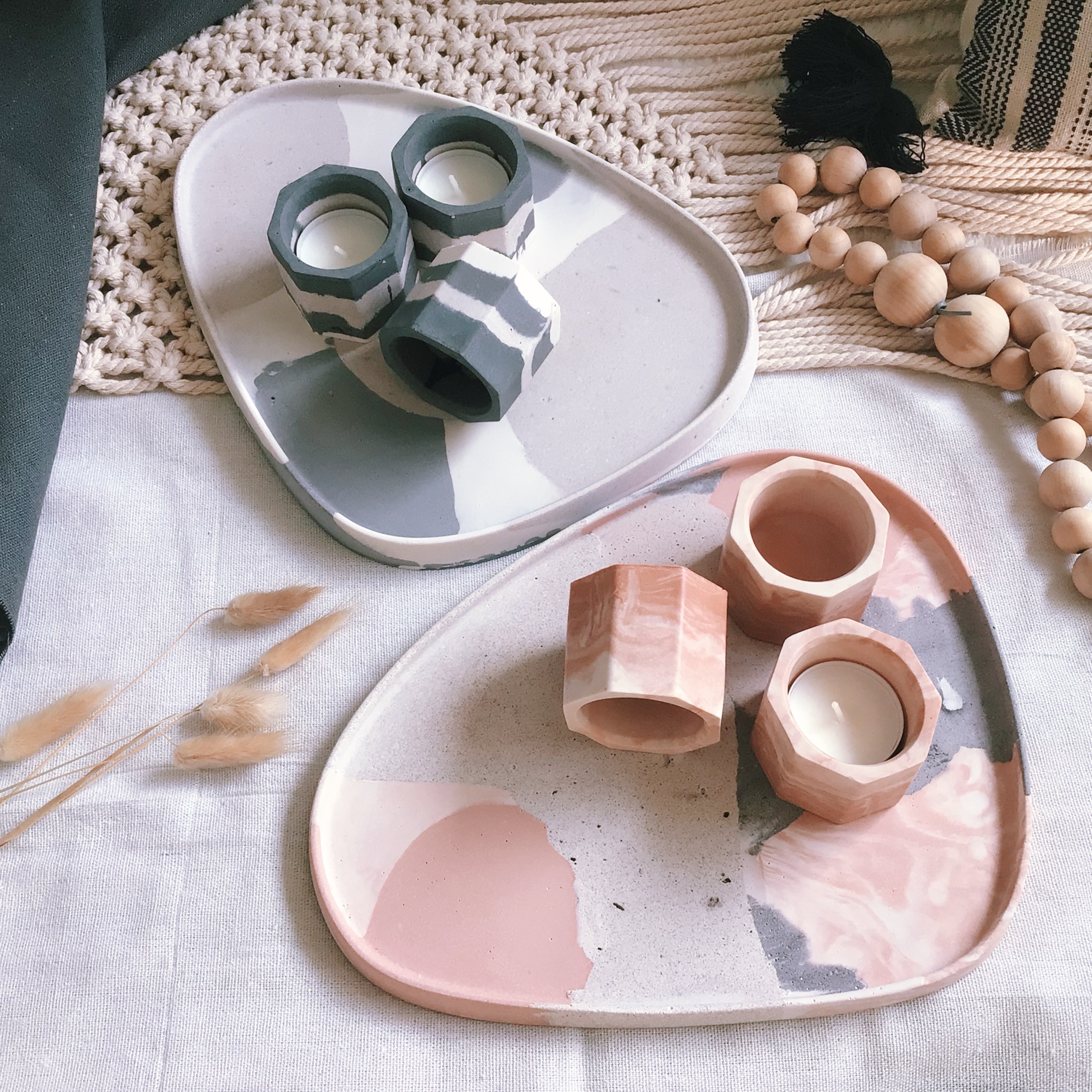 Terracotta tray with terracotta tealights next to a black and white tray with black and white tealights