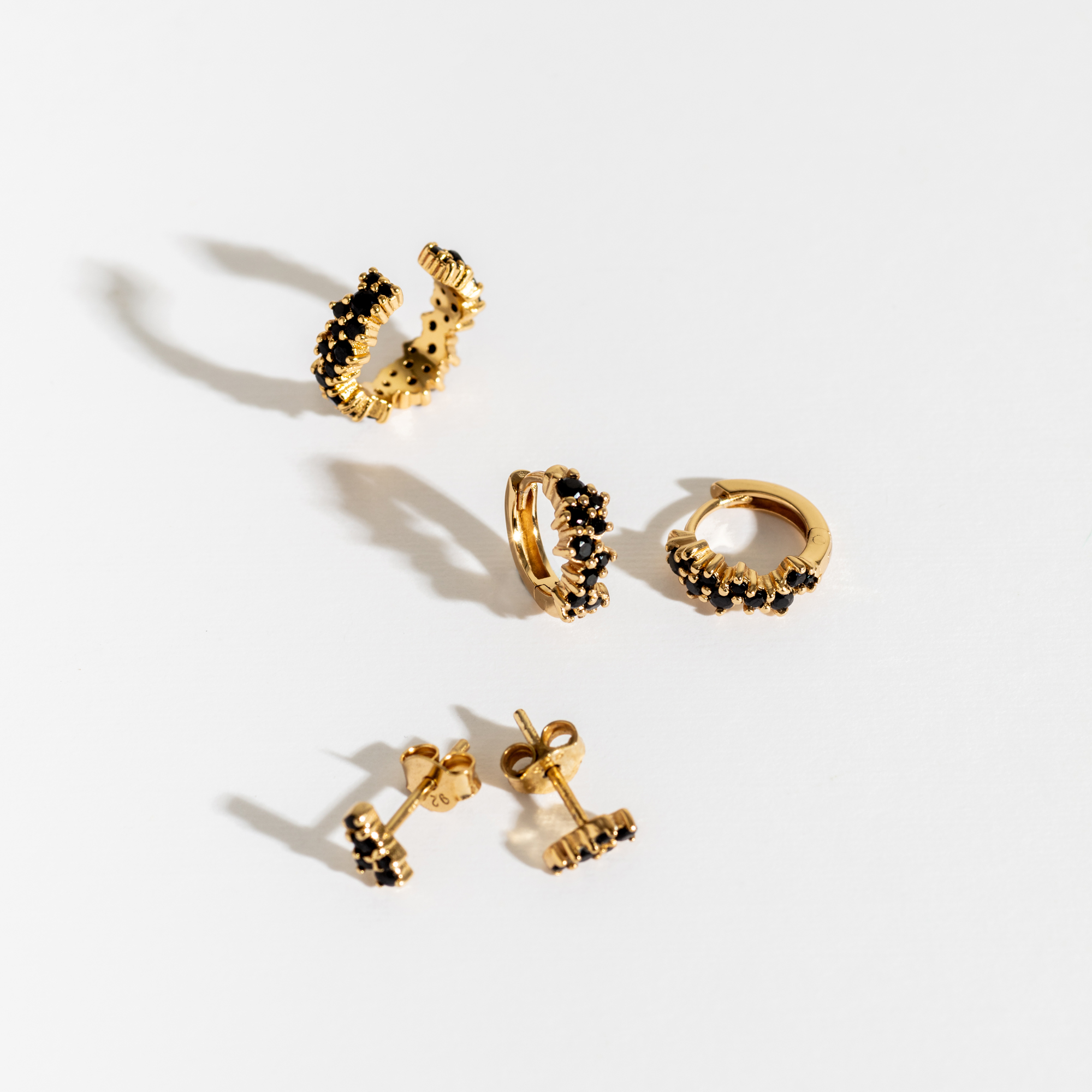 A collection of jewellery featuring glass teardrop earrings and teardrop pendant feather necklace