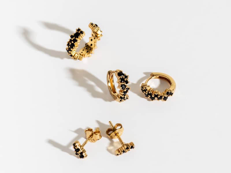 A collection of jewellery featuring glass teardrop earrings and teardrop pendant feather necklace