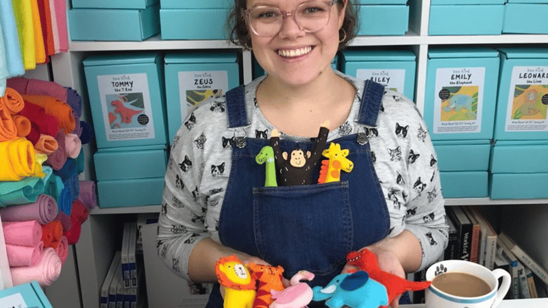 Bea, founder of the brand Bea Kind, holding various felt animals