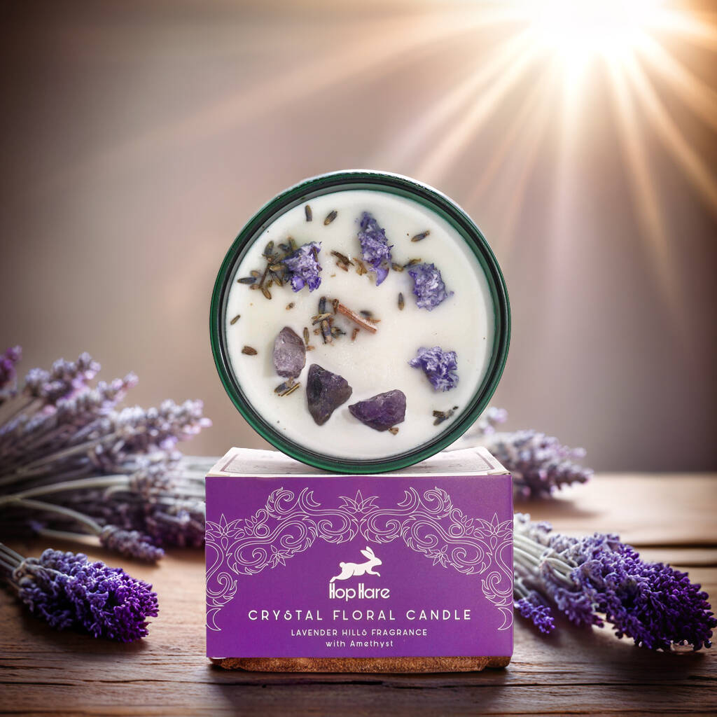 Lavender-scented floral candle with gemstones and real flowers in a glass jar with purple packaging.