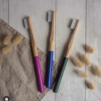 Three bamboo toothbrushes colours pink, blue and green