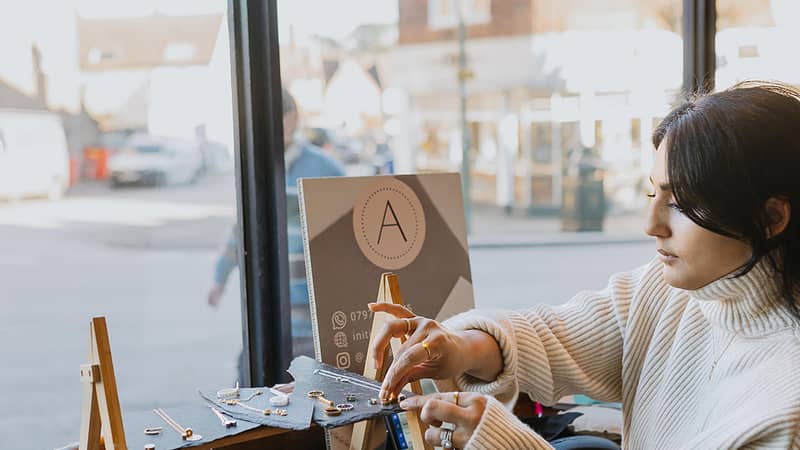 A photo of the business owner making jewellery at an event