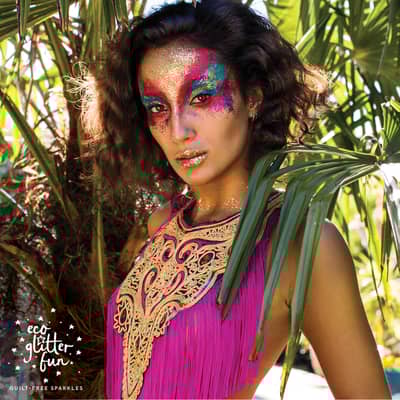 a girl with a glittery mask wearing a pink fringed festival top
