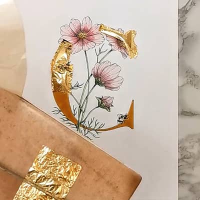 Gilding the letter C with loose gold leaf