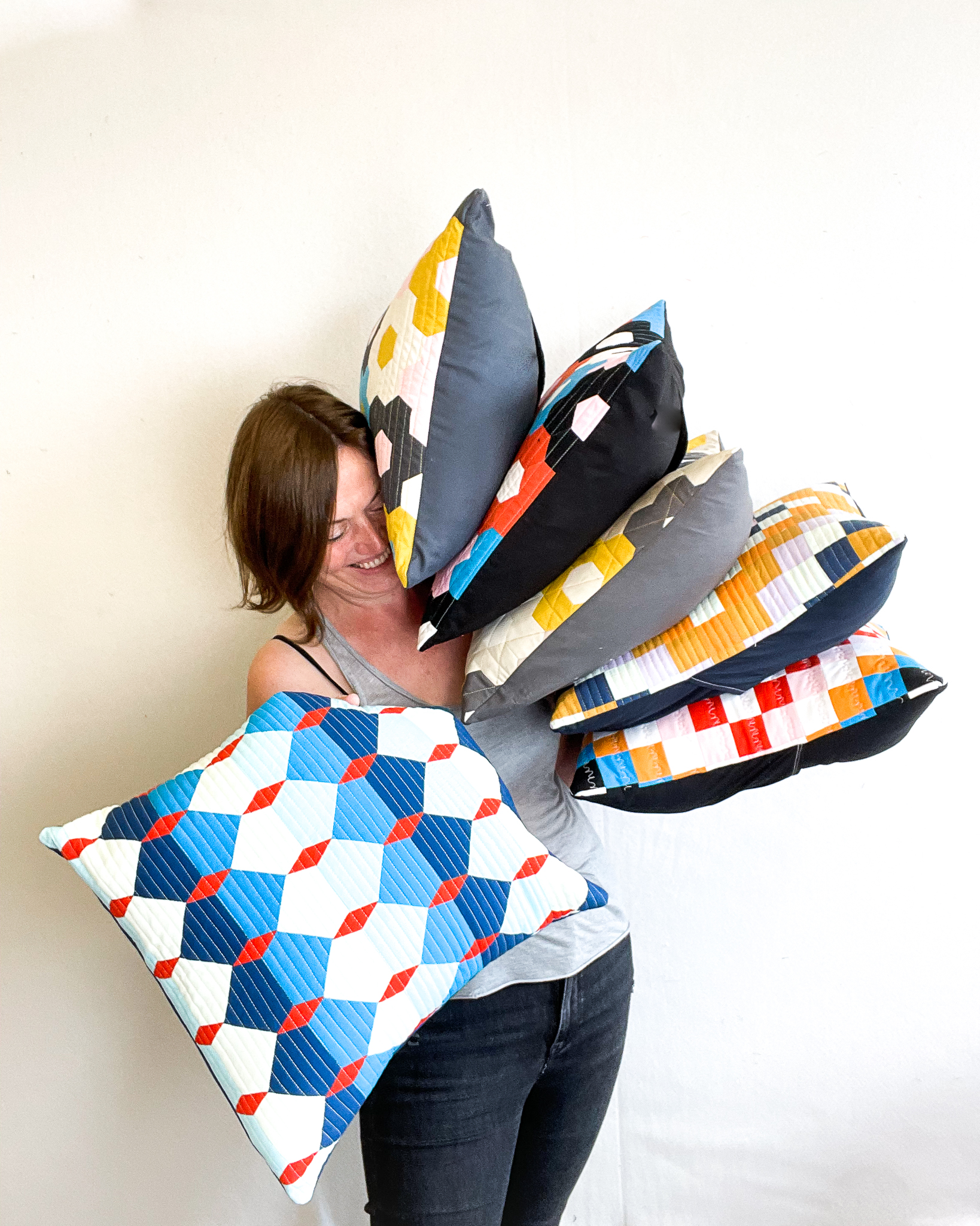 quilted hexagon cushion held up in front of Lucy Engels
