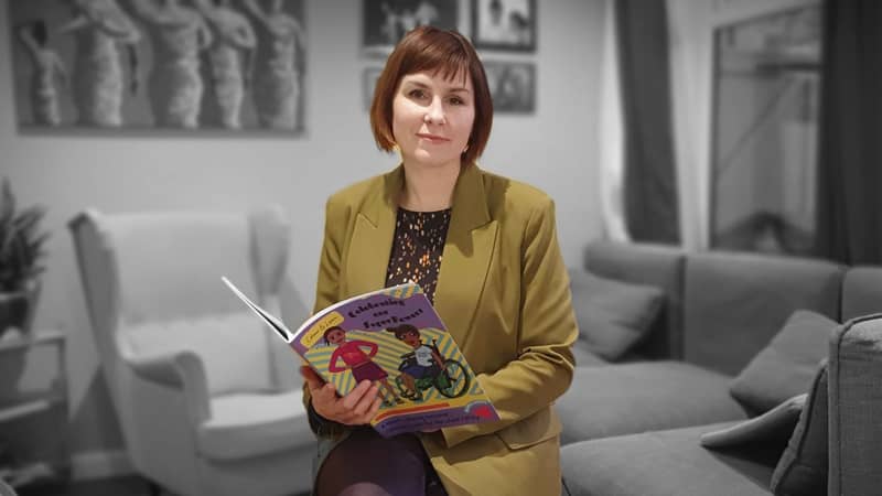 Picture of seller holding a book in her hands looking at the camera