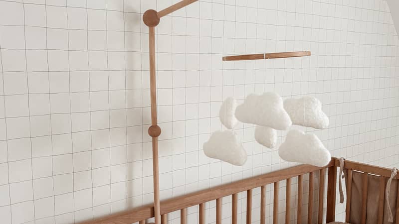 Handmade boucle cloud mobile and boucle cloud cushions. Neutral nursery decor