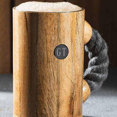 chuug rope handle coffee mug beer tankard with light rope and light oak wood finish outdoors in the mountains with pirate coin inlay