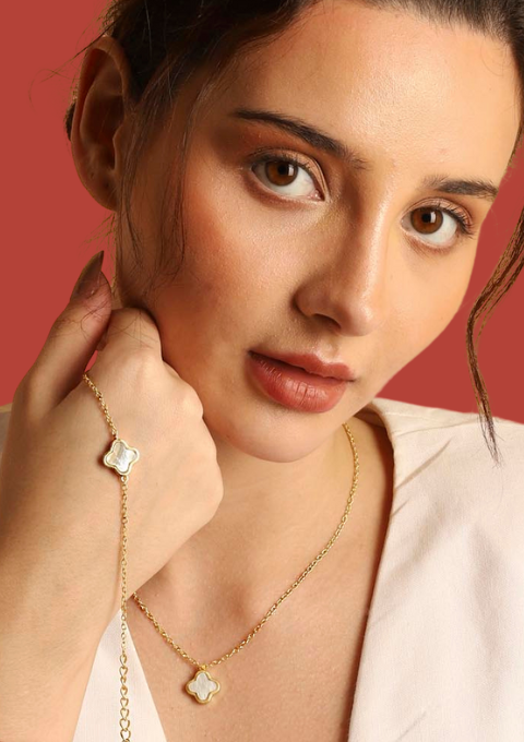 Finished jewellery pieces of necklace and bracelet with mother of pearl clover pendant adorned by a model.