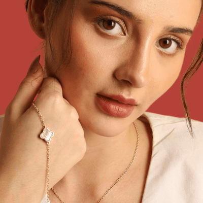 Finished jewellery pieces of necklace and bracelet with mother of pearl clover pendant adorned by a model.