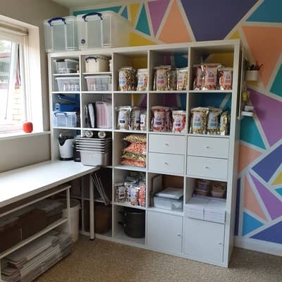 Big Shelving unit where Uniqucorn is made with popcorn on the shelves and a bright geometric wall behind