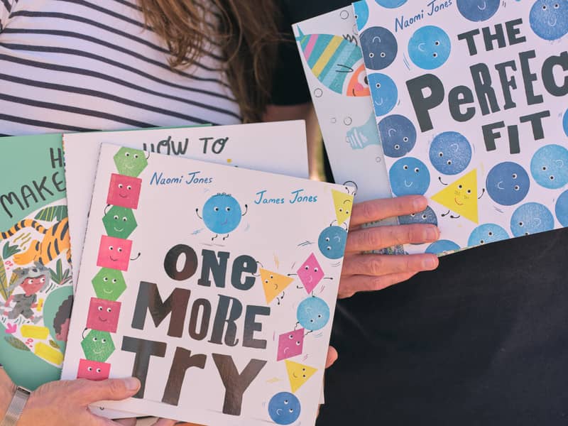 An image of Naomi and James holding some of their picture books