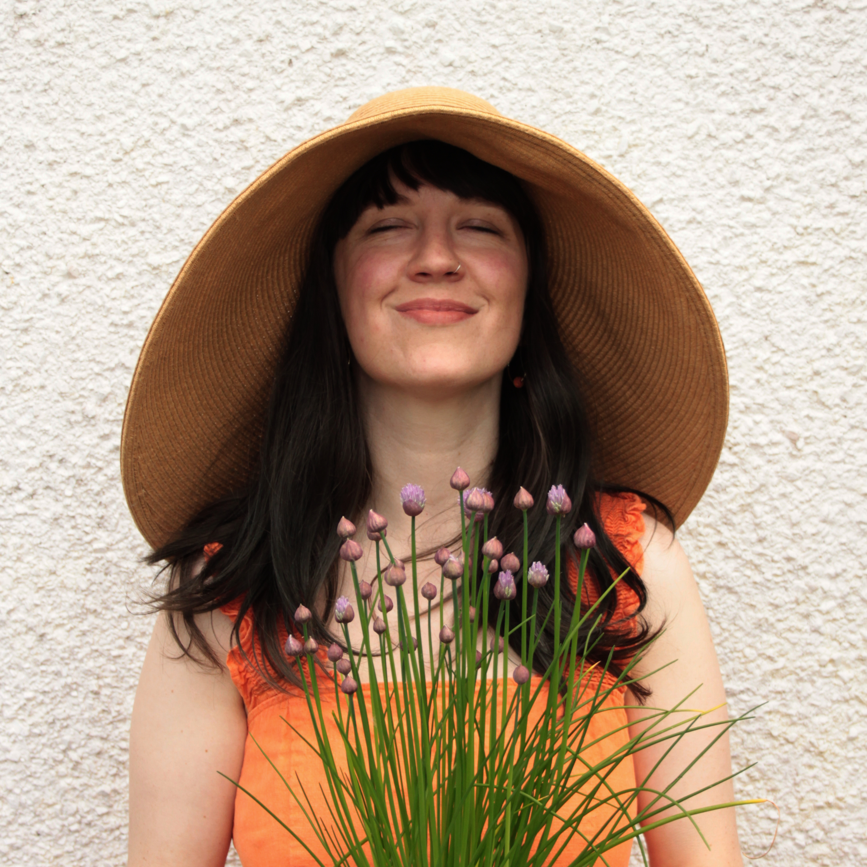woman in a garden holding potted plant