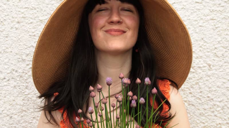 woman in a garden holding potted plant