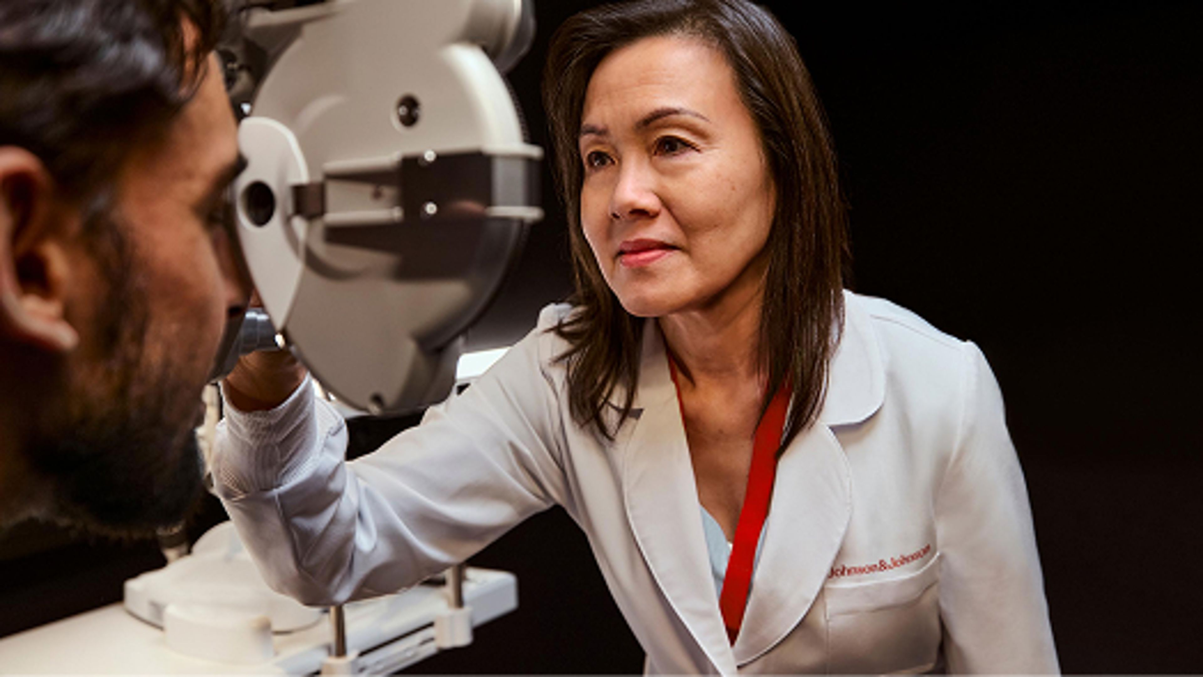 Doctor looking at patients eyes through machine