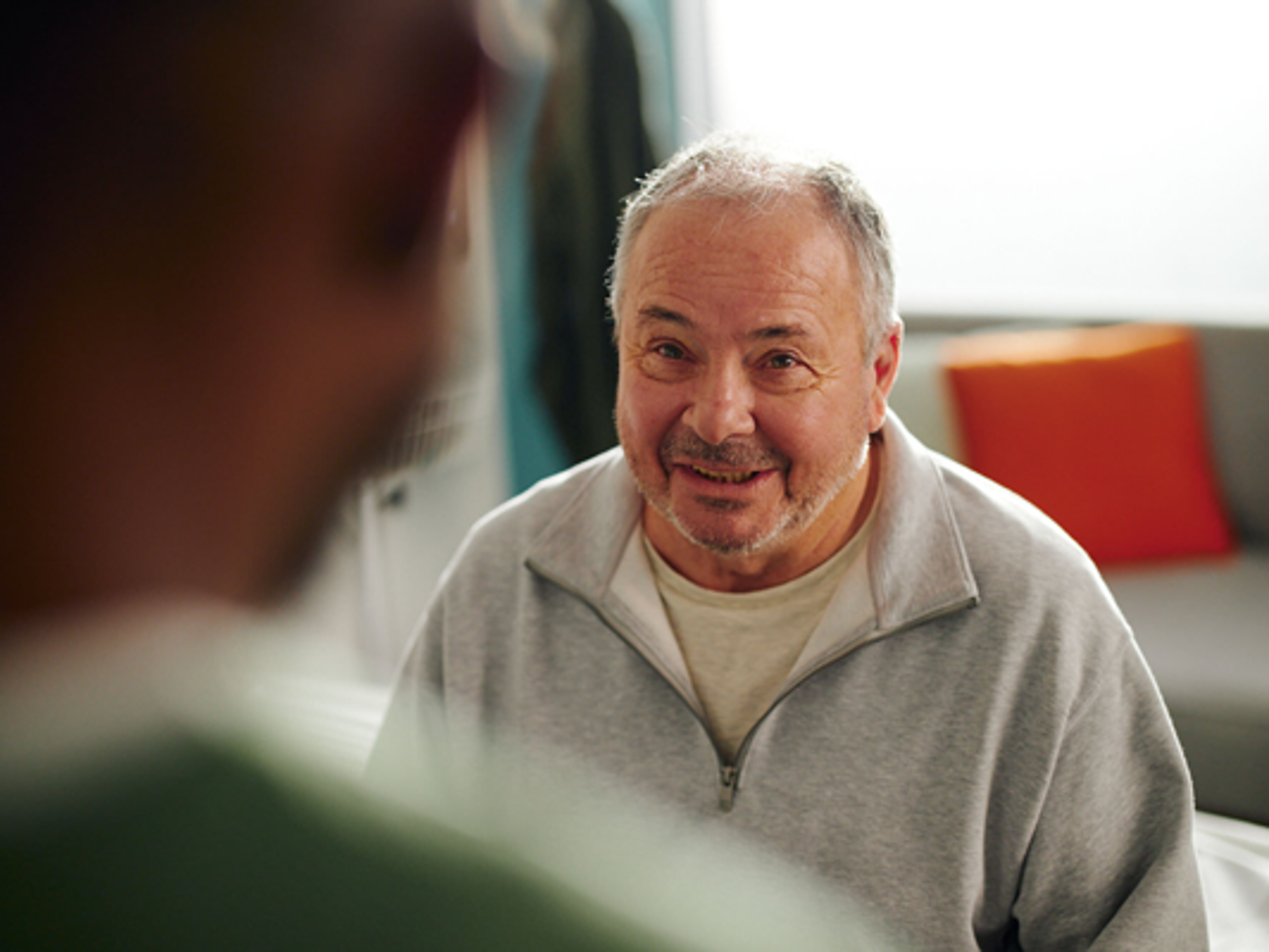 Man seated, listening to his physician.