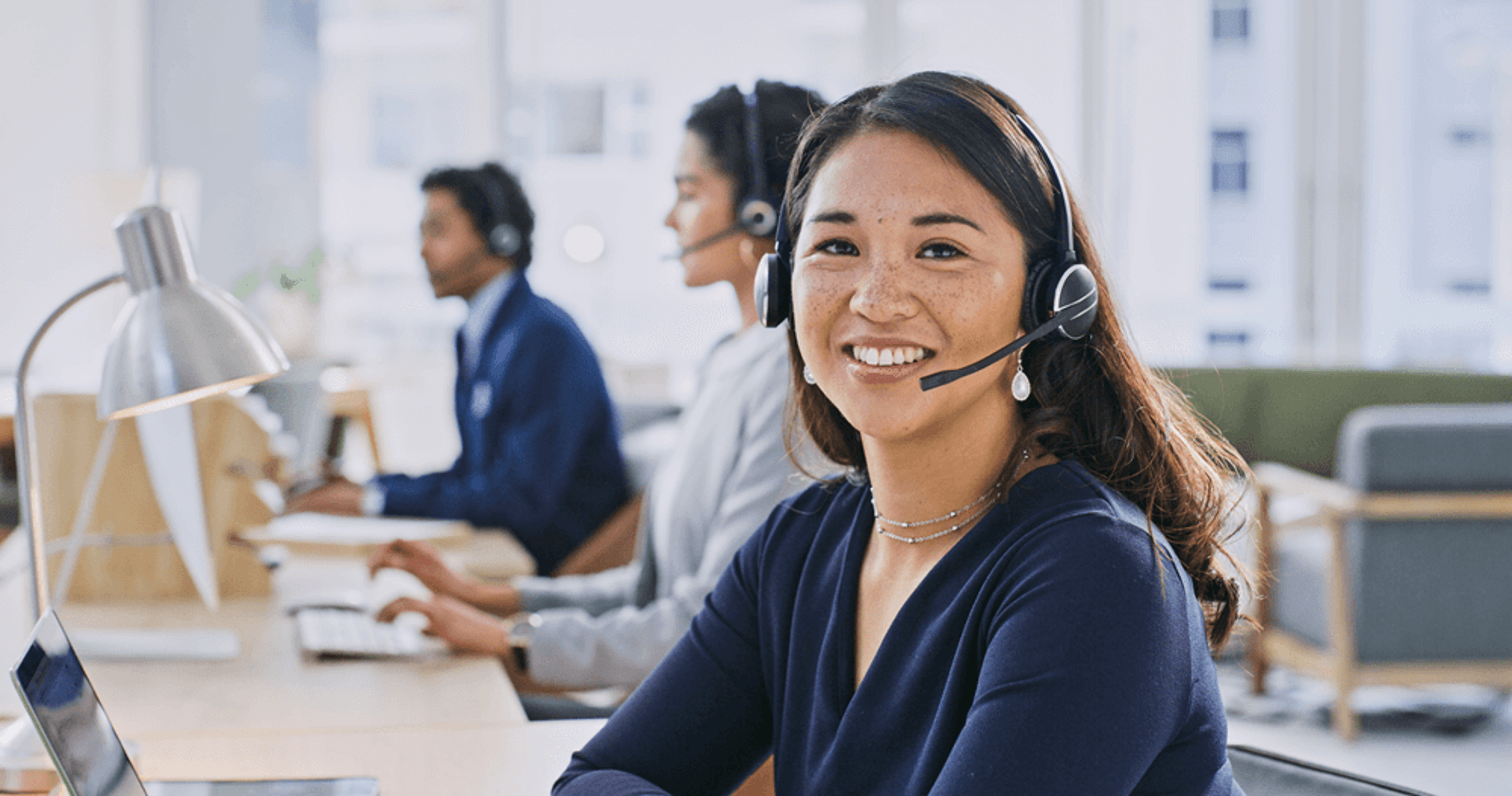 Call center associate smiling on call.