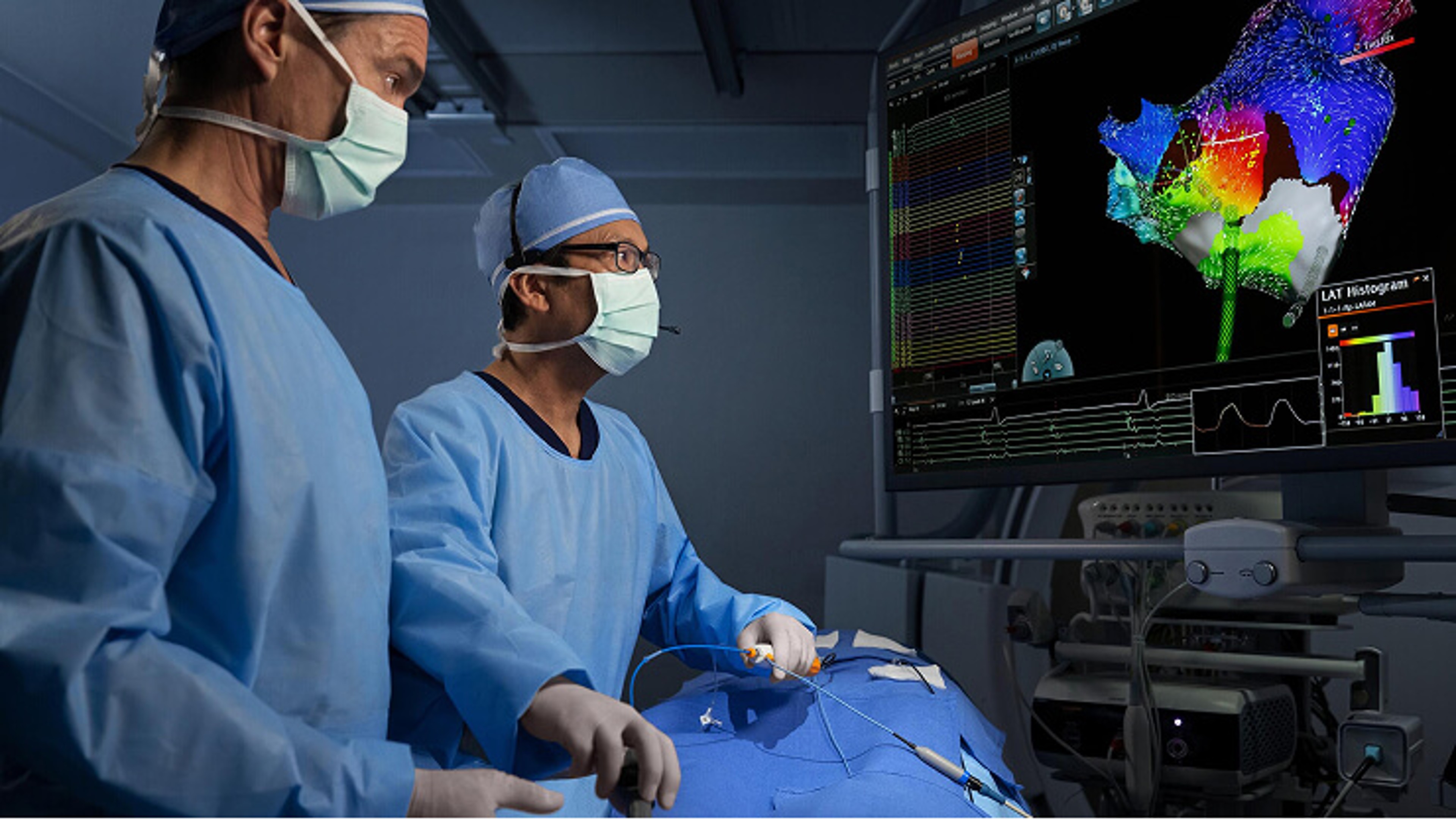 Two physicians in a procedure looking at the CARTO™ map of the heart.