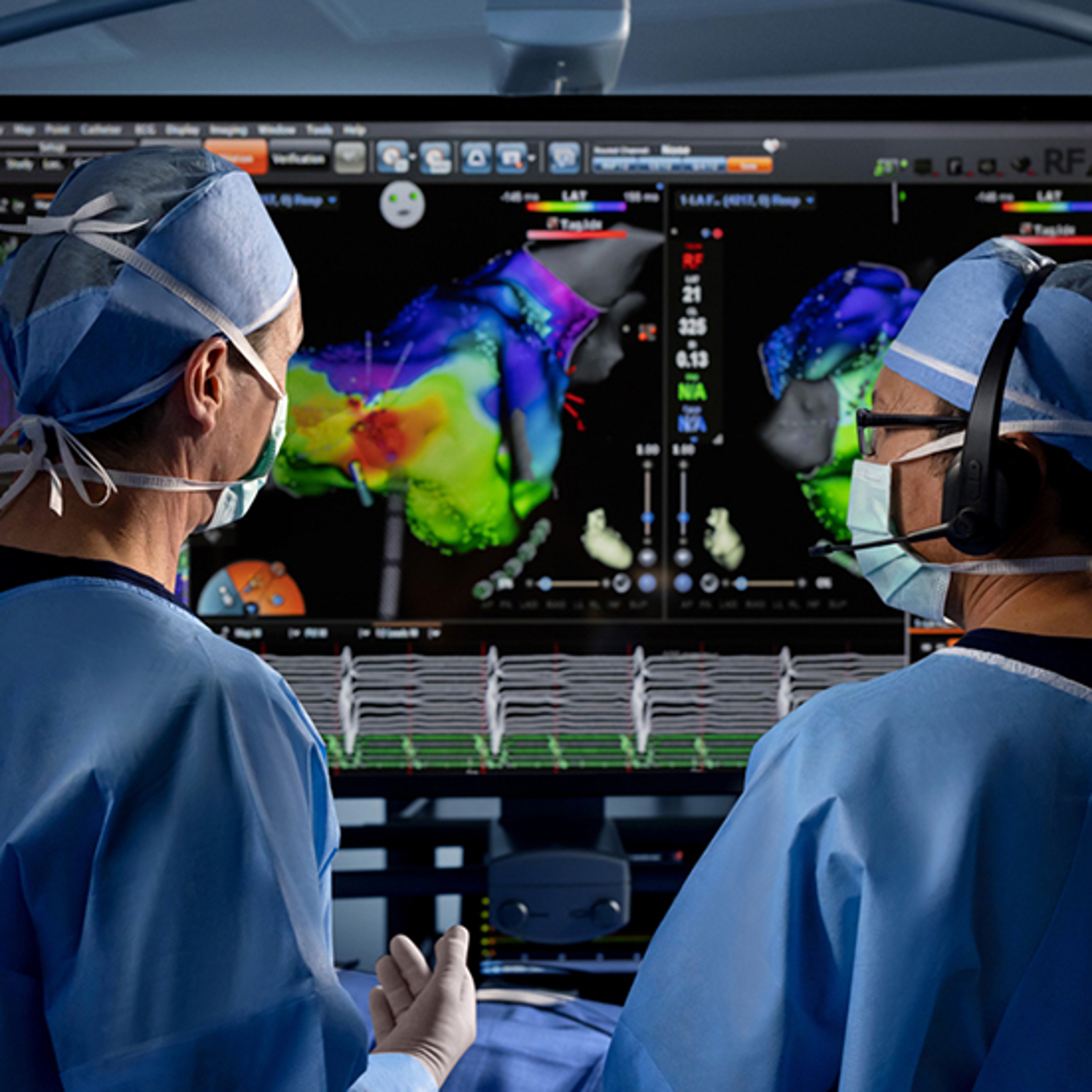 Two physicians in surgical attire and headsets stand at a workstation reviewing the CARTO™ System software map. 
