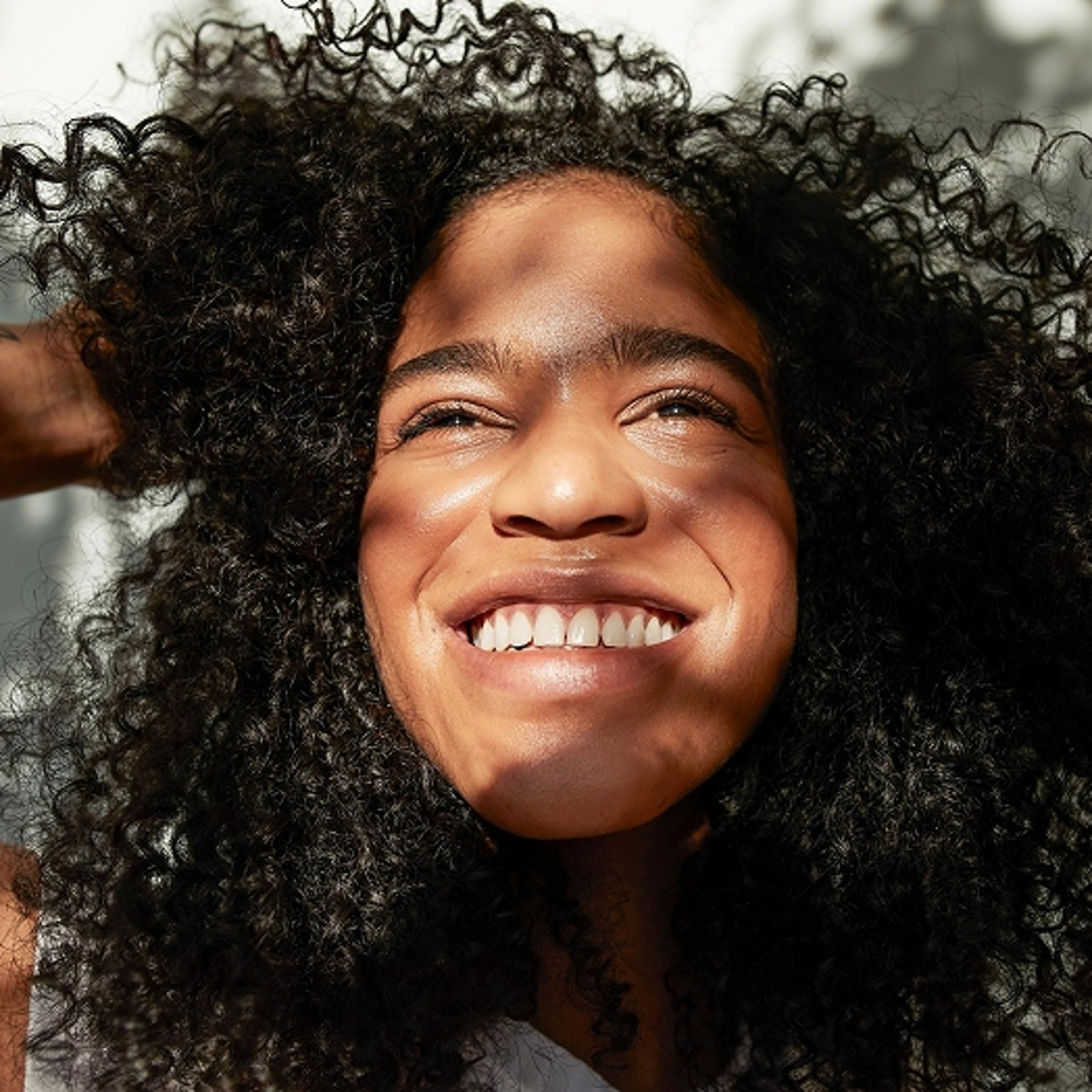 A woman smiling while the sun shines on her face