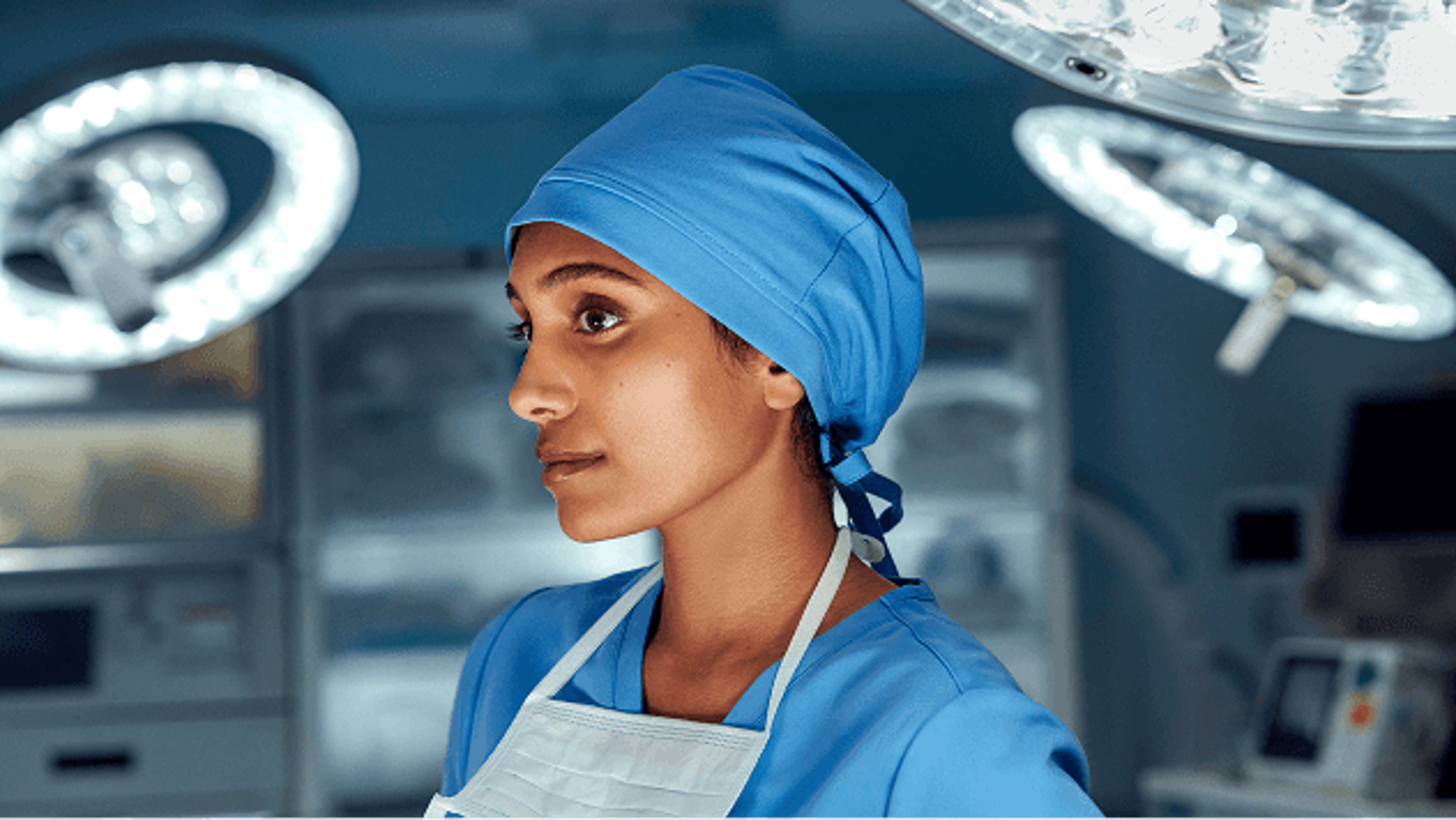 Side profile of woman in scrubs standing in the operating room.