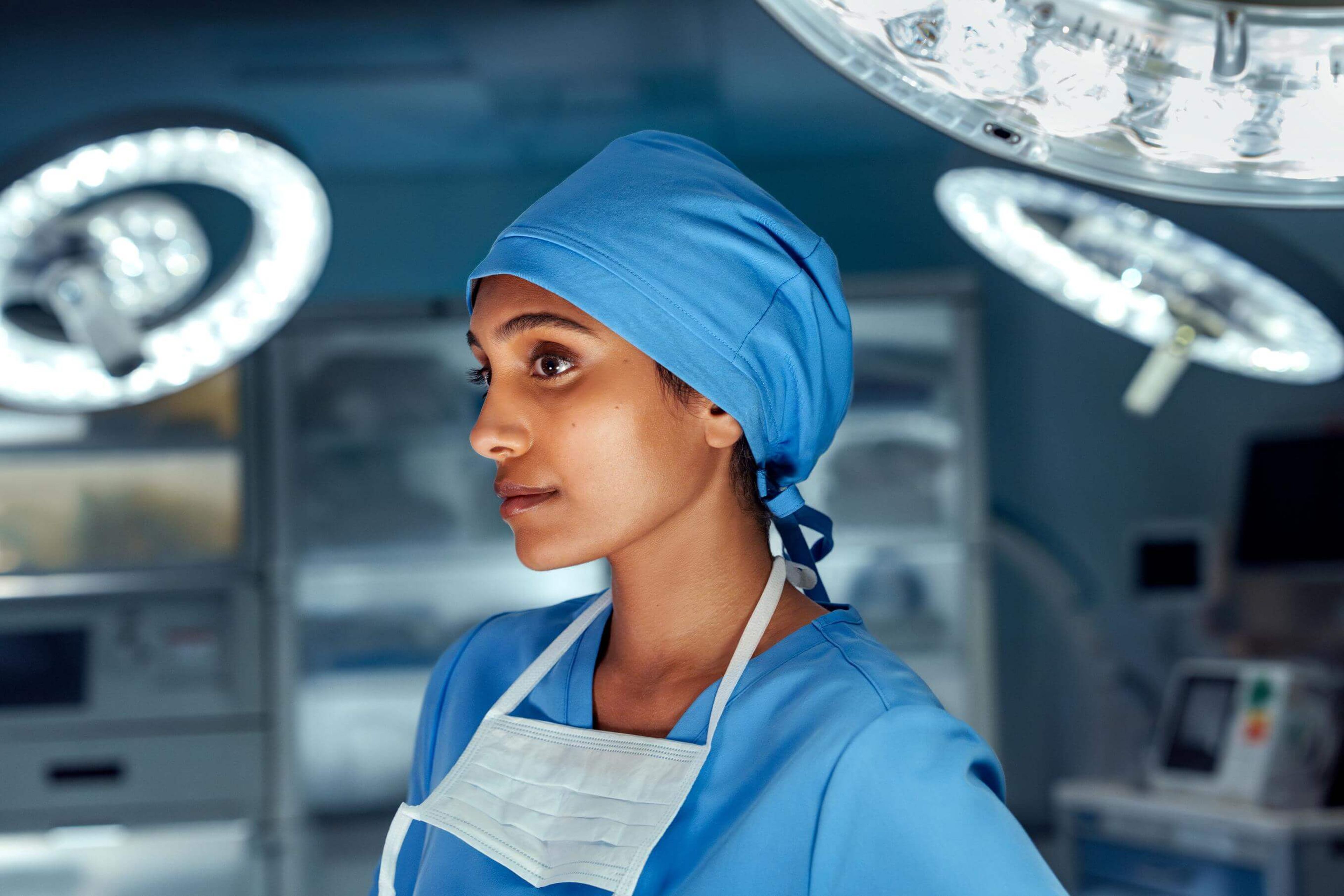 Side profile of woman in scrubs standing in the operating room.