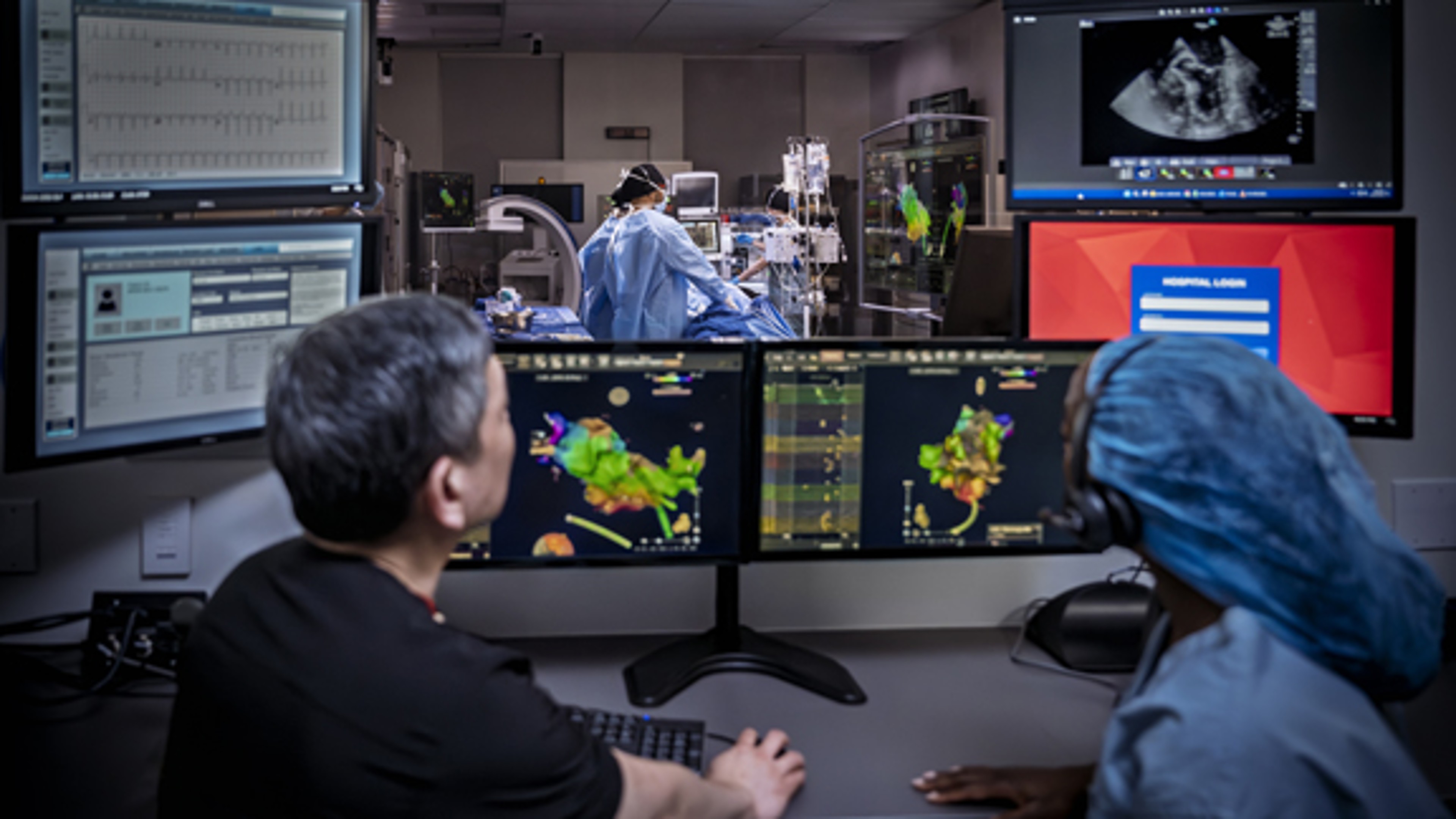 Clinical specialists in the control room looking into the procedure room during a case.