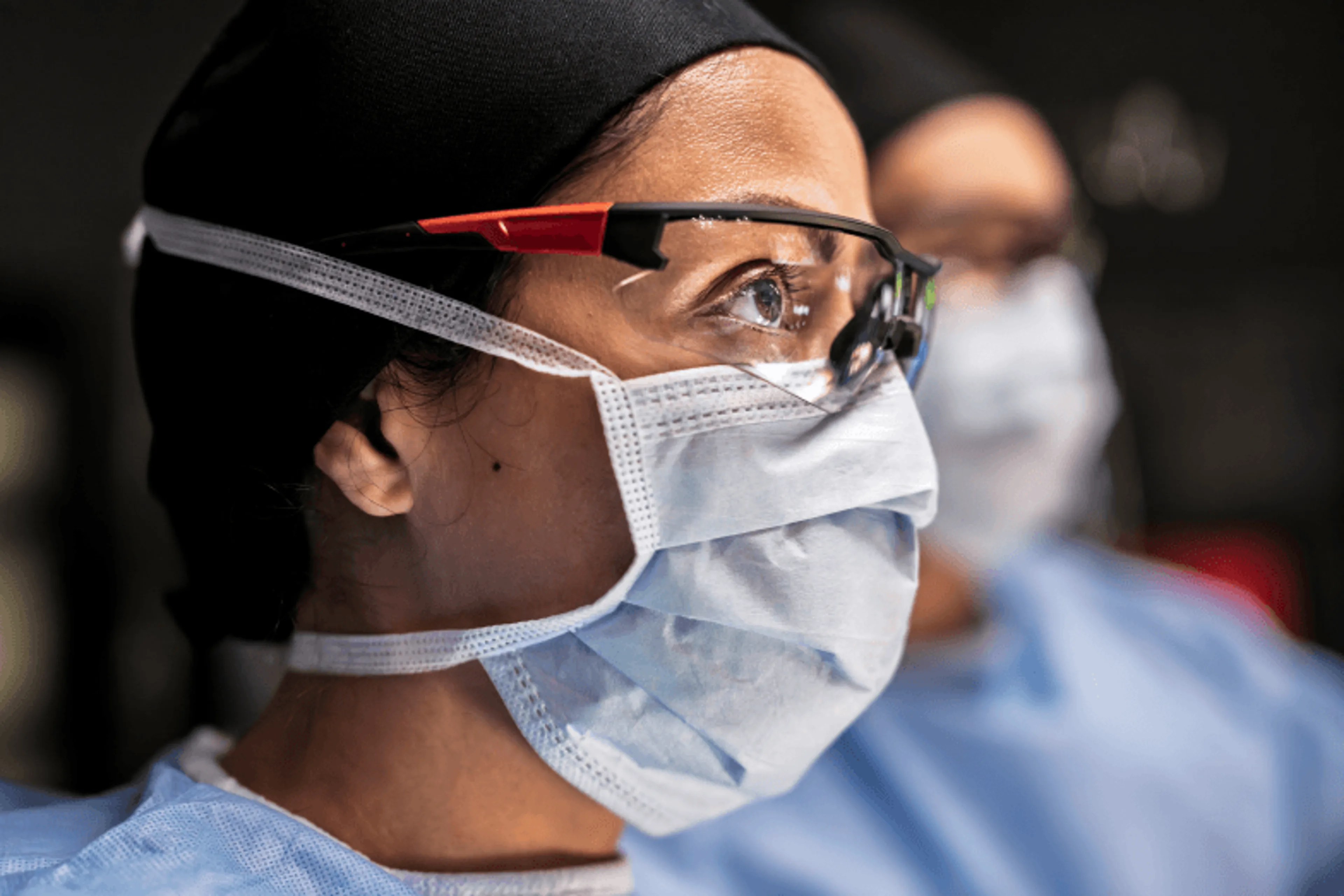 Profile view of a surgeon in glasses and mask