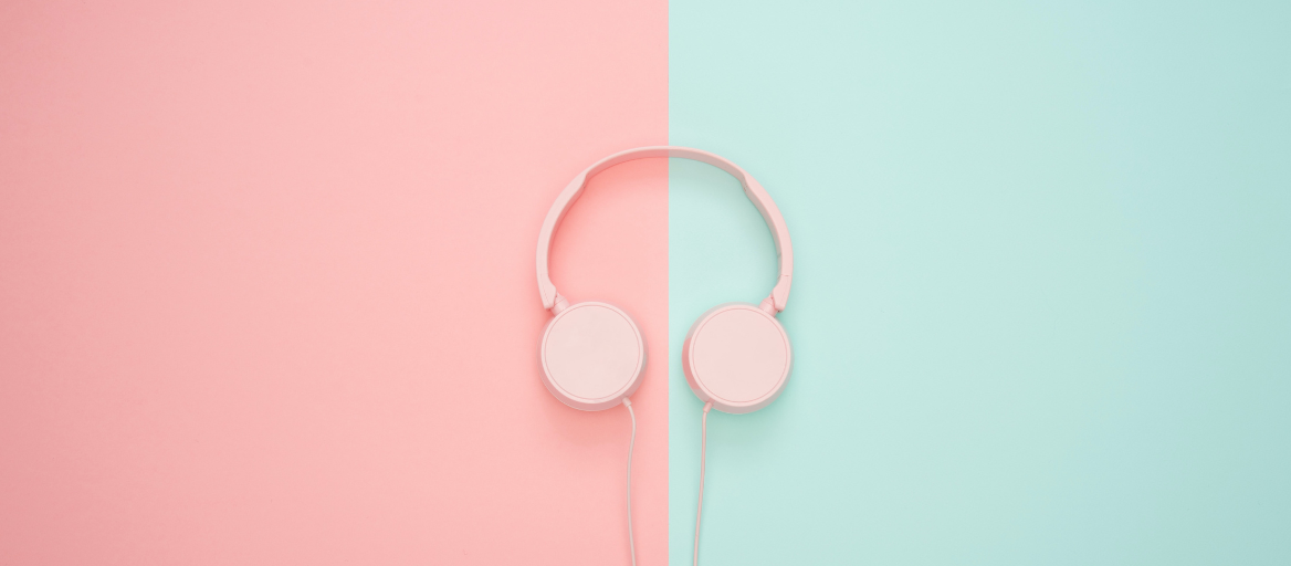 A pair of pink headphones on a pink and blue background.
