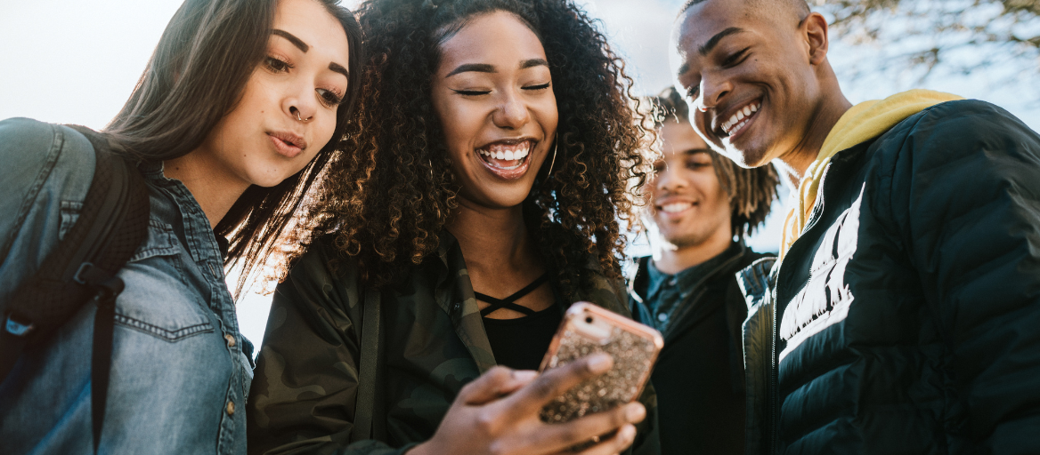 Group of people smiling at phone. 