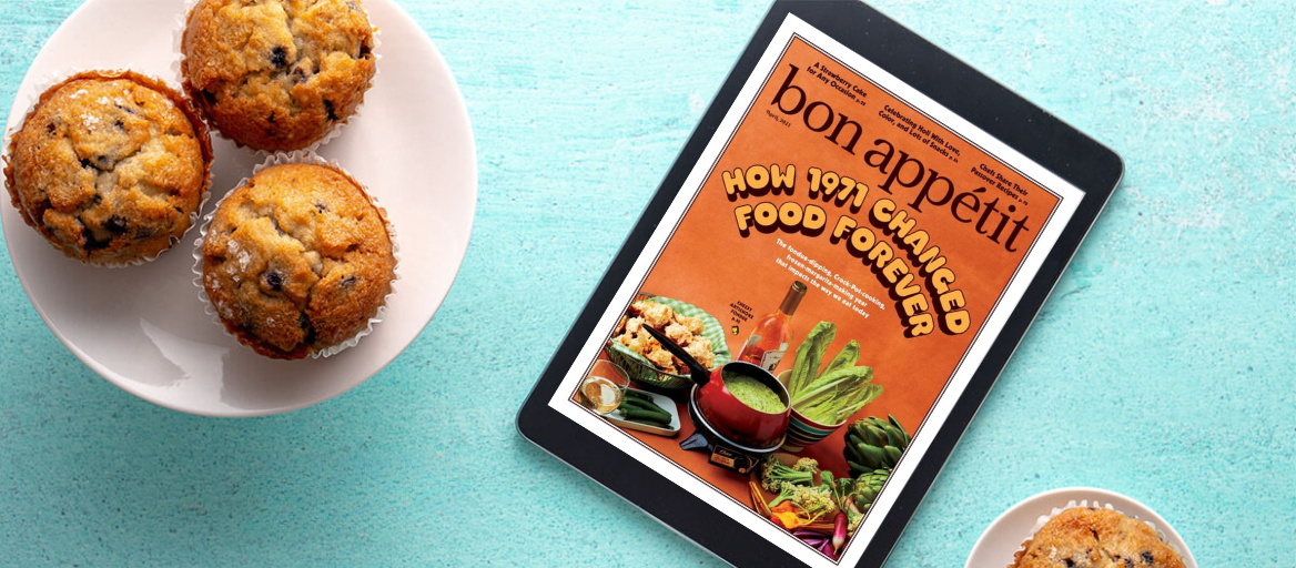 A plate of muffins sits on a blue table next to a tablet featuring the digital magazine cover of "Bon Appetit"