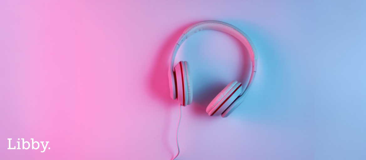 A photograph of headphones on a purple and pink shadowy background