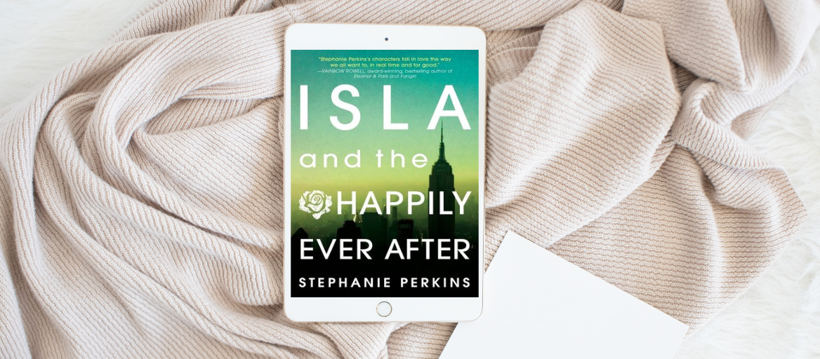A tablet with the book "Isla and the Happily Ever After" lays on a cozy cream-colored blanket